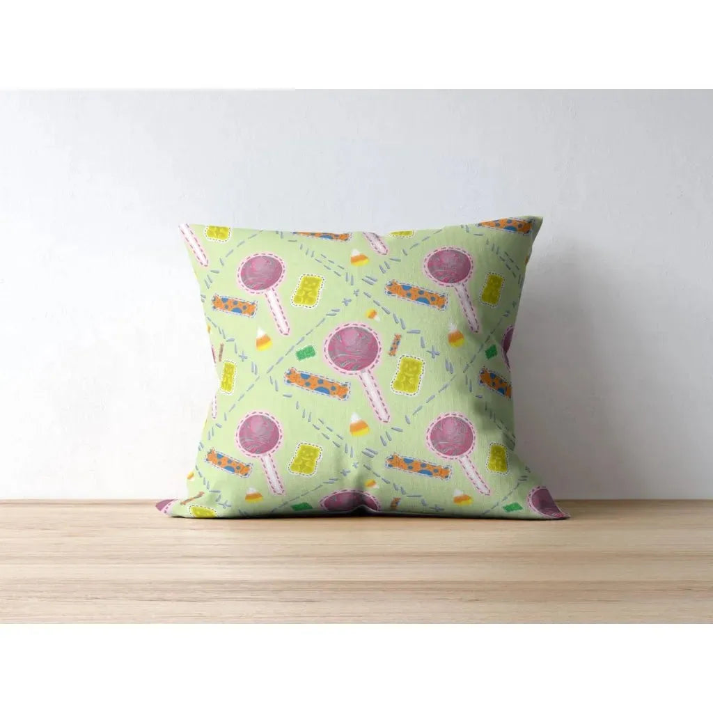 Square throw pillow mockup displaying a fun, repeating 'trick or treat' candy pattern on a lime green background.