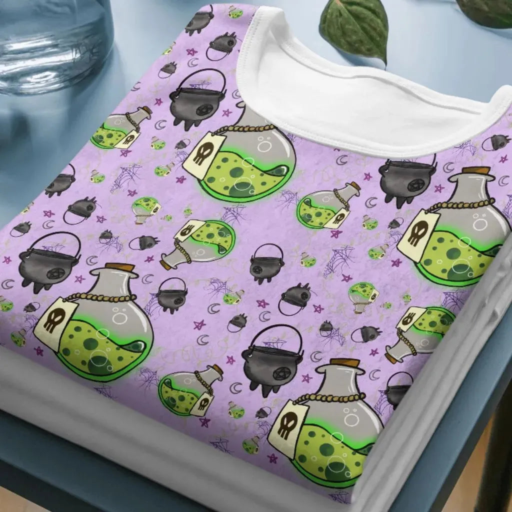 Close-up mockup of the witchy potions pattern printed on a folded short-sleeved t-shirt.