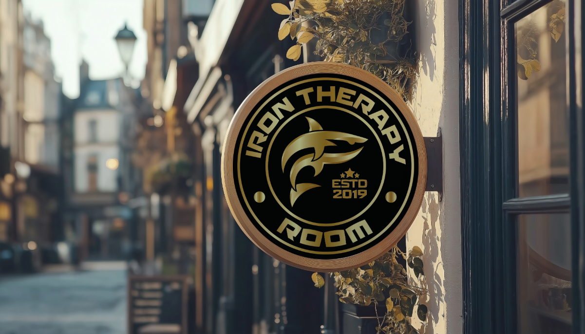 Black and gold Iron Therapy Room logo featuring a diving gold shark, Estd 2019.
