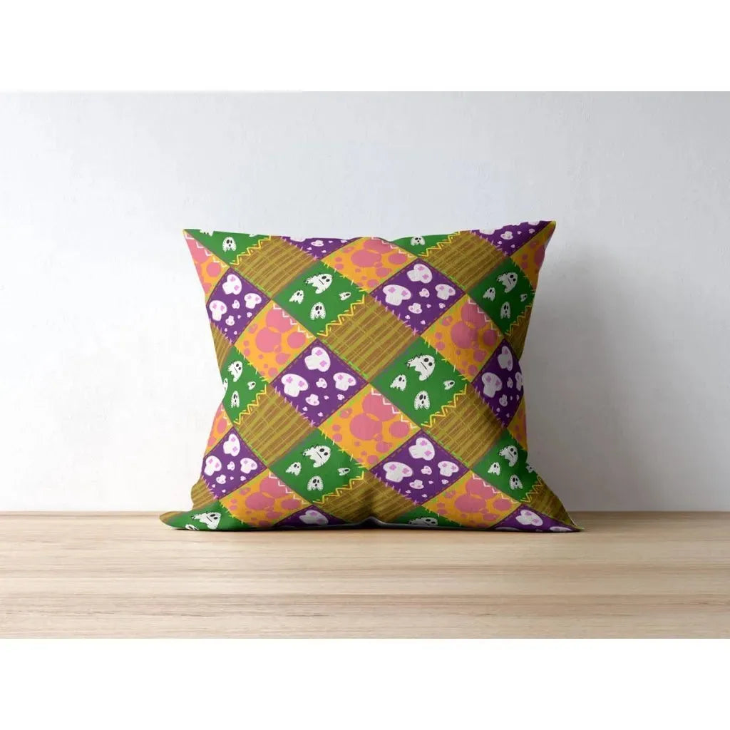 Close-up mockup of a single throw pillow showcasing the repeating patchwork ghost and skull seamless pattern on fabric.