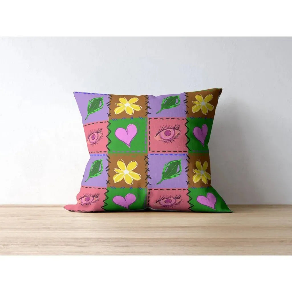 Throw pillow mockup displaying the quilt patchwork seamless pattern with bright hand-drawn hearts, flowers, eyes, and leaves.