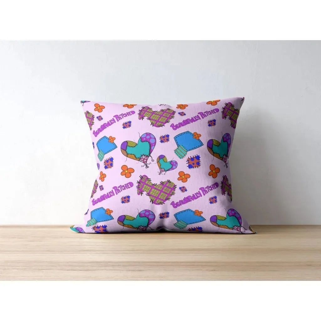 Throw pillow mockup displaying the Beautifully Patched seamless pattern with stitched hearts, patches, and flowers.