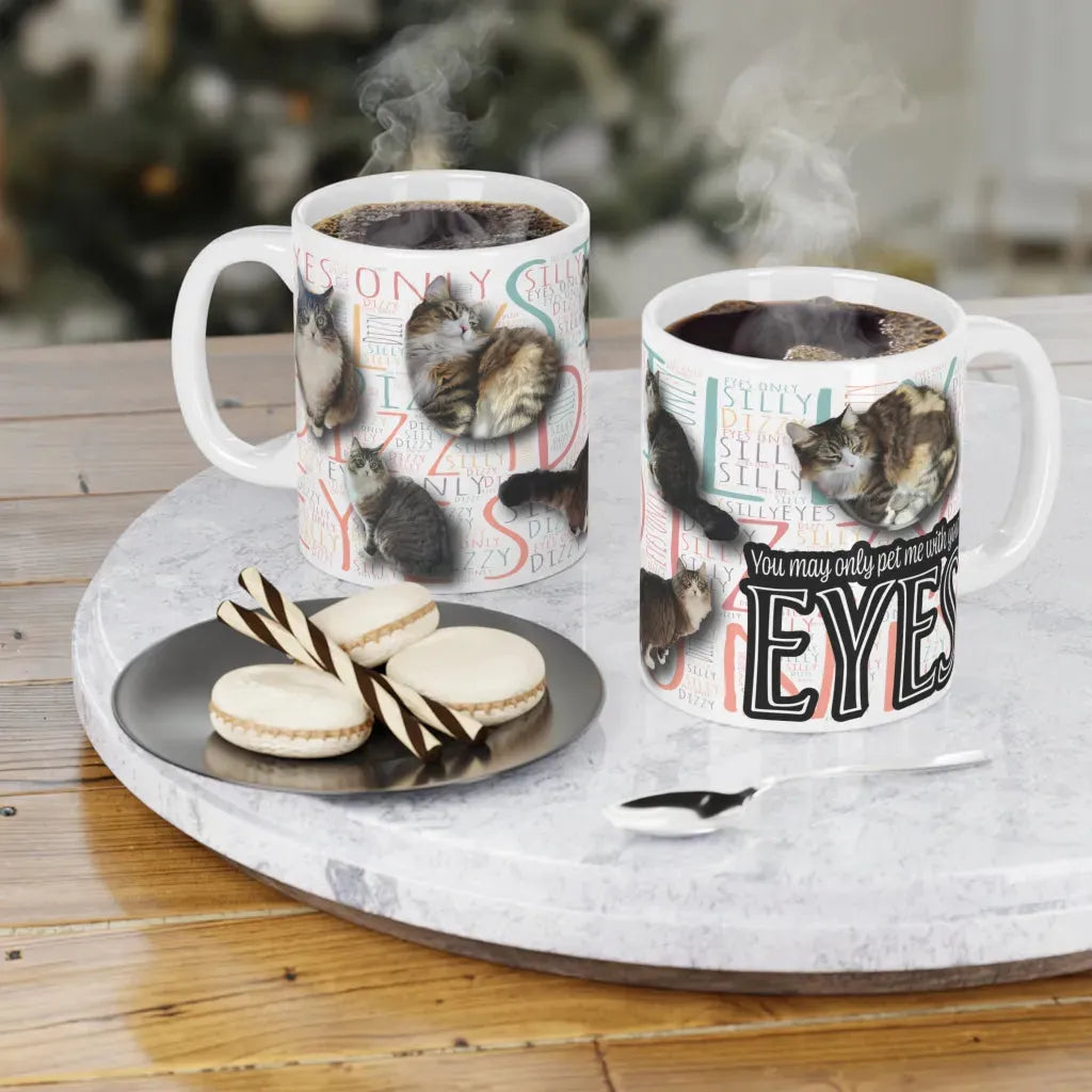 Two personalized ceramic mugs with colorful dog designs, steaming coffee inside, on a marble tray with cookies.