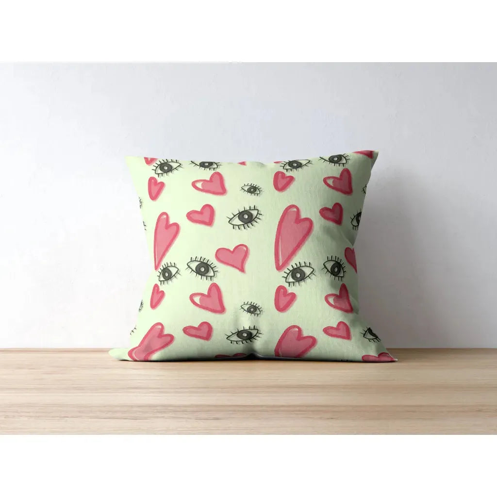 Throw pillow mockup featuring the hand-drawn eyes and hearts seamless pattern printed on fabric.