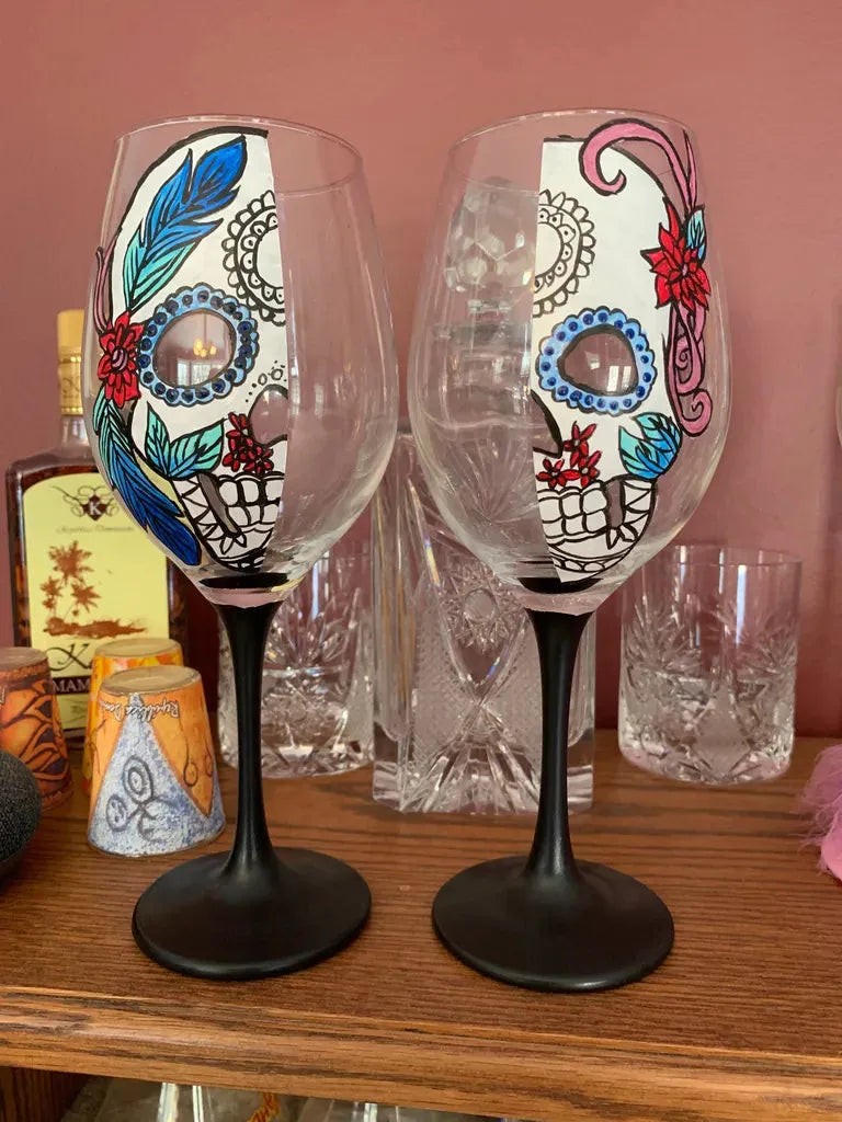 Hand-painted Sugar Skull Wine Glasses: Custom glassware featuring intricate floral Día de Muertos designs, perfect for unique home decor or gifts.